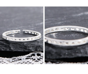 Macro detail of S925 sterling silver stamp on minimalist heart-shaped open ring