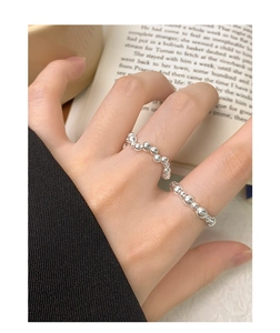Macro shot of polished S925 sterling silver beaded wave ring with shiny metallic texture