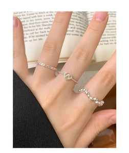Detailed view of three stackable S925 silver rings with hollow hearts and beaded texture