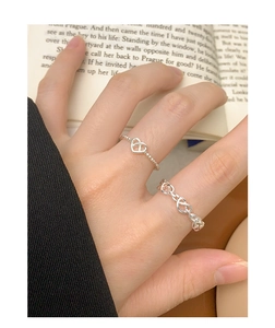 Detail of S925 sterling silver hollow heart ring set on a model with a vintage book