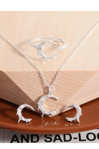 Detailed view of silver crescent moon jewelry set with textured lava finish and zircons