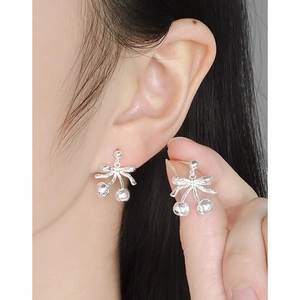 S925 sterling silver cherry bow earrings for women with textured metal finish on model
