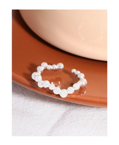 Detail shot of a minimalist S925 sterling silver beaded ring on a brown ceramic plate
