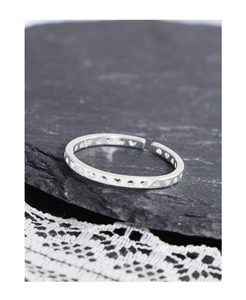 Detailed macro view of S925 sterling silver hollow heart ring on a black stone surface