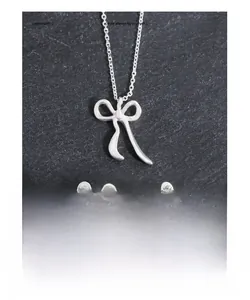 Close-up of S925 sterling silver bow jewelry set with polished necklace and earrings
