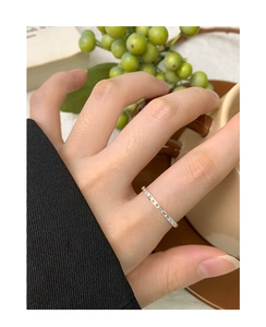 Detail of S925 sterling silver hollow dot ring worn on finger with a lifestyle background