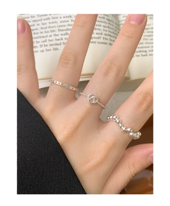 Stackable S925 sterling silver heart and beaded wave rings set on a woman's fingers
