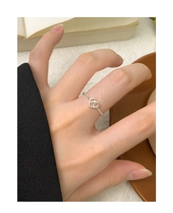 Detailed view of beaded silver heart ring worn on hand in a cozy lifestyle setting