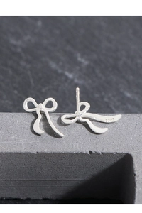 Macro shot of S925 sterling silver bow earrings with hallmark engraving on the back