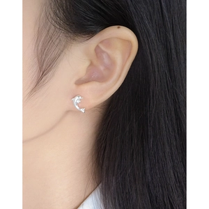 Minimalist S925 sterling silver dolphin stud earrings worn by a model in a close-up view