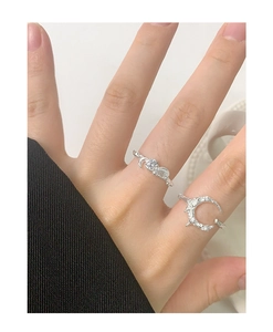Detail of S925 sterling silver moon and zircon rings on finger with textured finish