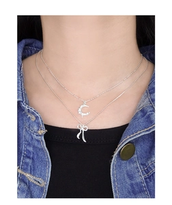Détail du collier S925 en argent avec croissant étincelant et pendentif en forme de nœud