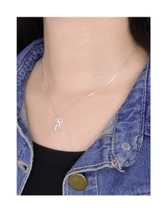 Détail du collier noeud en argent sterling S925 porté par un mannequin en jean