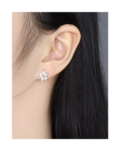 Macro view of S925 sterling silver hollow star earring worn on model earlobe