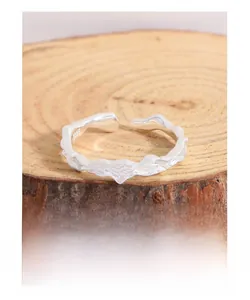 Macro shot of S925 sterling silver ring featuring an irregular lava texture on wood