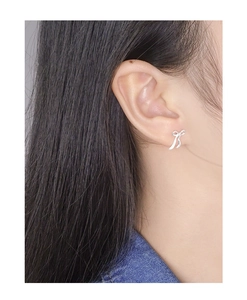 Close-up of S925 sterling silver bow ribbon stud earring worn on a female model