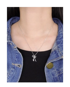 Détail d'un pendentif nœud irrégulier en argent S925 sur une fine chaîne élégante