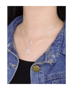 Détail d'un collier double épaisseur en argent S925 avec pendentif nœud sur un mannequin