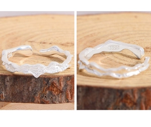 Close-up of S925 sterling silver ring showing lava texture and hallmark on wood
