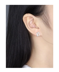 Close-up of minimalist hollow star stud earring in S925 sterling silver on earlobe