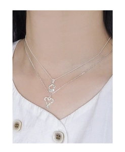 Detail of layered S925 silver necklaces with irregular textured star and heart pendants