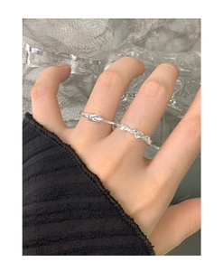 Detail of S925 sterling silver rings featuring lava texture and elegant knot design