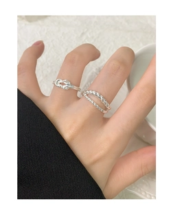 Close-up of S925 sterling silver knot and twisted rope ring layers on model fingers