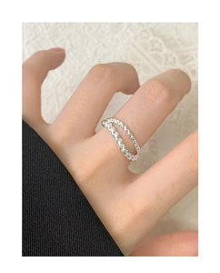 Detailed close-up of double-layer twisted silver rope ring worn on woman's index finger