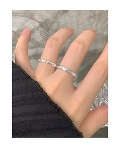Detailed view of silver stackable rings featuring a twisted texture and smooth finish set