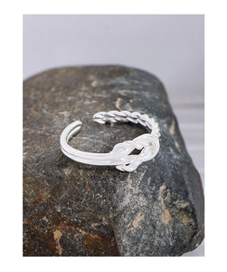 Macro shot of 925 sterling silver twisted rope knot ring on black stone background