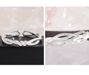 Macro view of S925 sterling silver stamp on minimalist twisted cross open ring