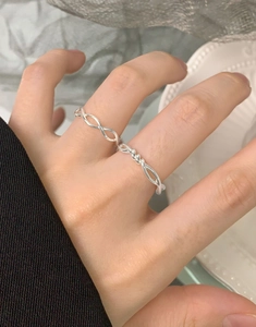 Close-up of S925 sterling silver twisted ring with elegant wave design on a woman's finger