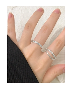 Detail of S925 sterling silver double-layered twisted rope rings worn on a hand