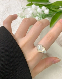Primo piano di anello in argento S925 con intarsio in conchiglia a cuore indossato