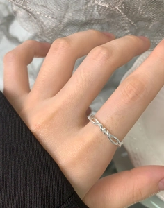 Macro shot of S925 sterling silver twisted ring showing intertwined double-line texture