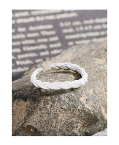 Detail of twisted rope silver ring showing the S925 hallmark on a natural stone base