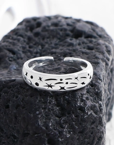 Macro detail of S925 sterling silver ring with star and moon patterns on lava stone