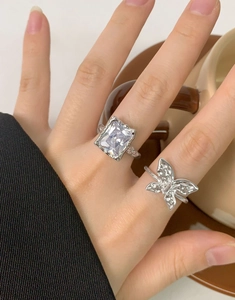Detail of S925 silver ring with rectangular zircon and butterfly design on model's hand