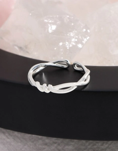 Close-up of S925 sterling silver stamp on minimalist twisted hollow crossover ring band