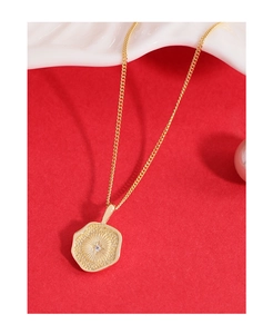 Vue macro du pendentif irrégulier en or 18 carats avec motif soleil sur fond rouge
