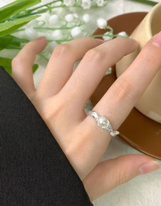 Eleganter S925 Silberring mit unregelmäßiger Textur und weißer Perle am Finger