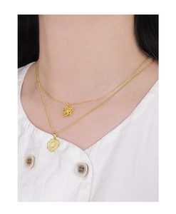 Gros plan de colliers superposés en argent S925 avec médaille irrégulière et pendentif fleur