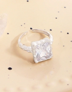 Macro detail of S925 sterling silver stamp on textured lava ring with square zircon