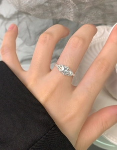 Macro detail of S925 sterling silver star ring featuring spiral design and hollow lines