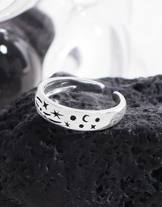 Close-up of S925 sterling silver ring with hollow star and moon patterns on lava stone