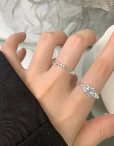 Close-up of S925 sterling silver spiral ring and hollow star ring on a finger