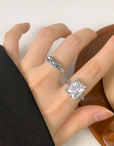 Detail of square zircon and blue emerald-cut rings in S925 silver with lava texture