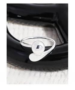 Macro view of minimalist S925 silver ring featuring a geometric bead and teardrop element