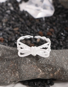 Detailed view of S925 silver double-layer bow ring with twisted texture on grey stone
