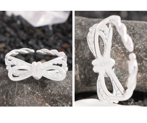 Macro detail of S925 sterling silver stamp and woven double-layer bow ring design